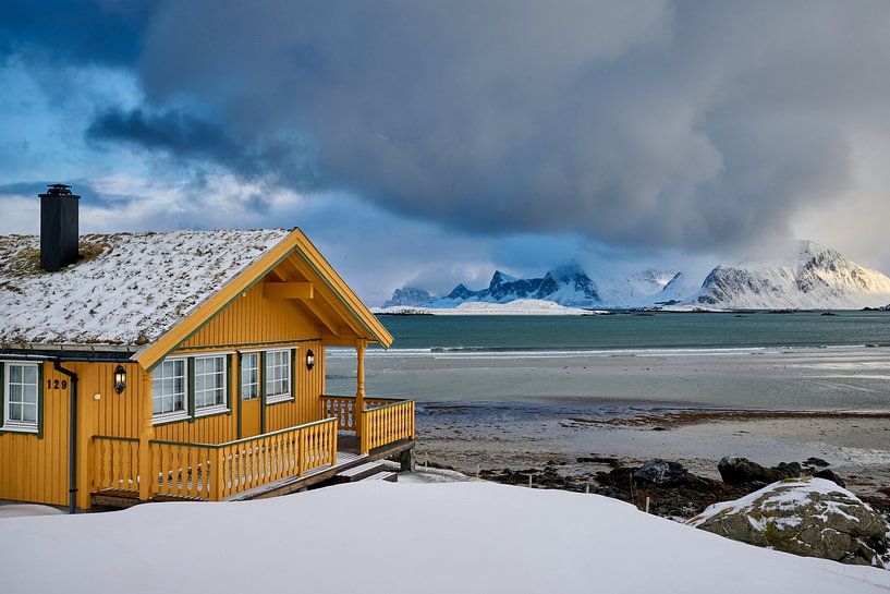 hoelzernes gelbes Haus oder Huette in Winterlandschaft bei stürmischen Wetter  mit Meer und Bergen von Jürgen Ritterbach