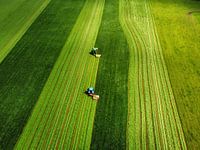 Two tractors mow the first cut of the year