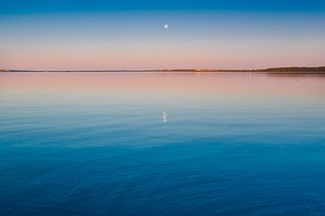 Het turquoise meer bij zonsopgang. glad blauw en turquoise meeroppervlak bij zonsopgang, rood en ora van Michael Semenov