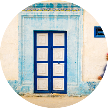 Oude man loopt voor gevel in Medina van Monastir Tunesië