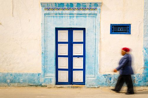 old man walks in front of facade in medina of Monastir Tunisia
