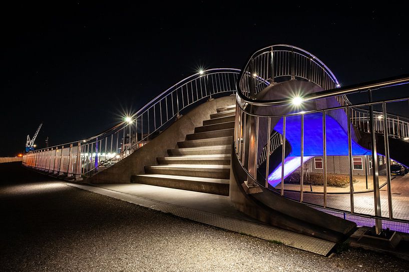 Futuristische verlichte publieke werken met trappen, voetgangerspad en train viaduct van Fotografiecor .nl