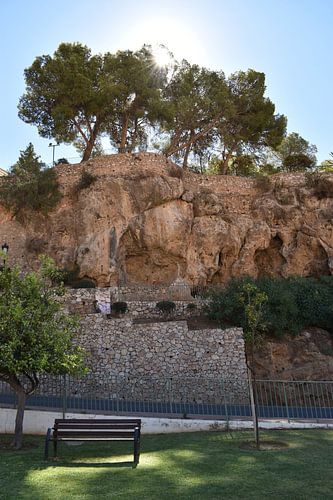 Een bankje in het park onder de rots