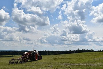 Een tractor in een veld tijdens de oogst van Claude Laprise
