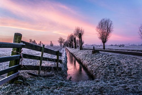 Sloot, weg en hek in het ochtendgloren