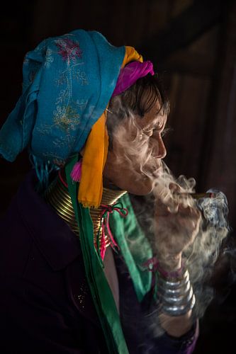 Old woman smokes traditional cheroot cigar in front of her home in Baghan in Myanmar