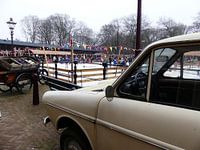 Oude auto met zicht op een schaatsbaan