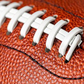 A close-up photograph of an American football showing the detailed texture of the leather by Mustafa Kurnaz