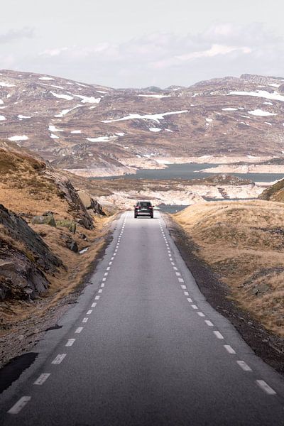 Voiture sur une route déserte dans un paysage de montagne norvégien | Photographie de voyage Lofoten par Dylan gaat naar buiten