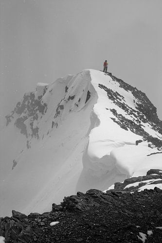 Klimmen op de top van een besneeuwde berg in een sneeuwstorm. met sneeuw en ijs