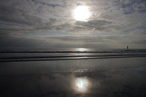 Grijze wolken en zon op het Noordzeestrand