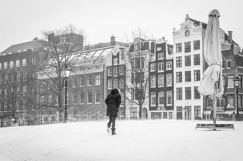 Wandelaar trotseert de snijdende wind en sneeuw in hartje Amsterdam