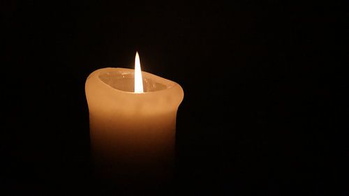 Brandende kaars in het donker