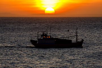 Zonsondergang met vissersboot op zee bij Mui Ne in Vietnam van Roland Brack