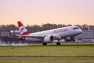 Austrian Airbus A320neo landt op Schiphol tijdens zonsondergang van Maxwell Pels