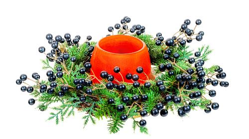 Kerstdecoratie met een kaars in een glas op een witte achtergrond