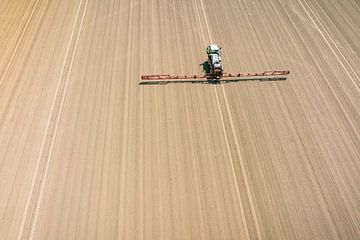 Agriculutural crops sprayer in a field seen from above by Sjoerd van der Wal Photography