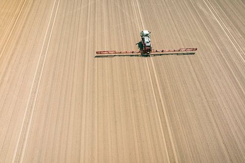 Landbouwspuiter in een veld van bovenaf gezien