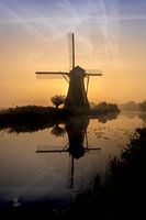 Hollandse molen bij een mistige zonsopkomst