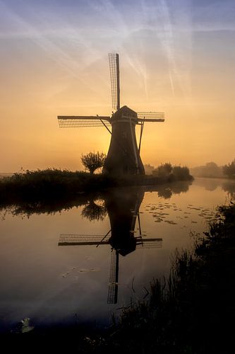 Moulin hollandais au lever de soleil brumeux