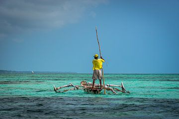 Visser staand in zijn visserbootje oceaan Zanzibar van Erwin Floor