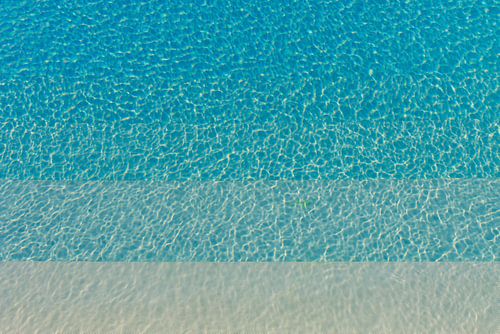 Verschillende soorten blauw kabbelend water in een zwembad met zonneschijn