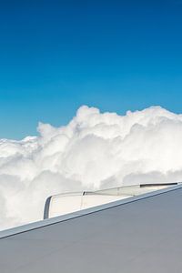 Airplane wing with engine and clouds