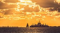 Zonsondergang met zeilboot en veerboot op het Wad van Martijn van Dellen thumbnail
