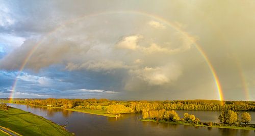 Regenboog tijdens een herfstbui boven de IJssel