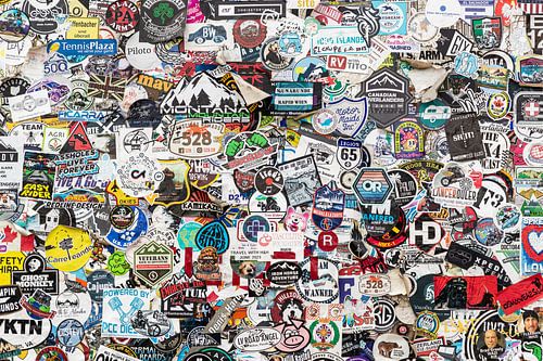 Bord met honderden stickers van Amerika van Inge van den Brande