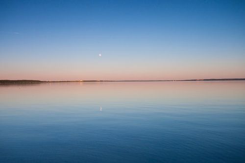 The turquoise lake at dawn. smooth blue and turquoise lake surface at dawn, red and orange and sky b