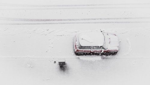 Red car in snowy landscape