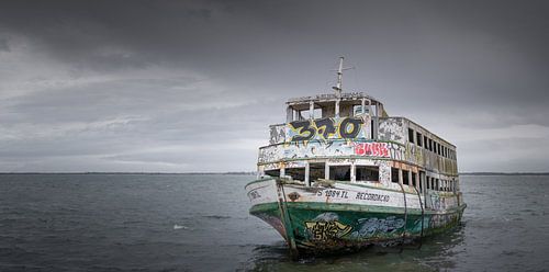 Abandoned ship with graffiti on the open sea