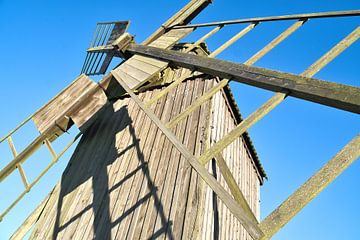 Vieux moulin à vent en bois dans un paysage idyllique sous un ciel bleu