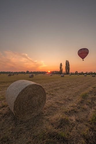 Luchtballon boven land met hooirollen