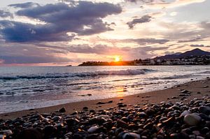 ondergaande zon aan het strand op Kreta van Joke Troost