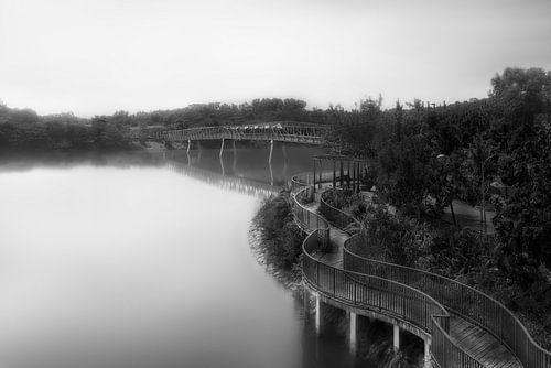 Romantische rivier met brug in Azië in zwart-wit.