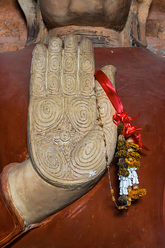 Buddha’s hand with a garland of flowers