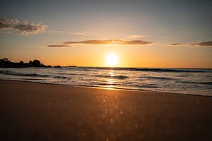 Sonnenaufgang am Strand an der Küste Sardiniens mit glitzerndem Meer