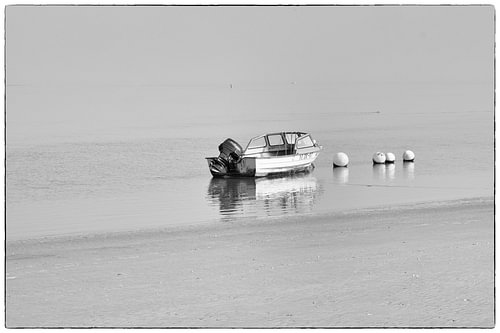 Kleines Motorboot aus Holz auf dem Wattenmeer in Schwarz-Weiß