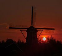 Zonsondergang achter een molen.