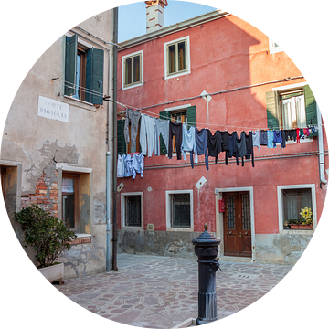 Huis aan plein met pomp op Murano, Venetie, Italie van Joost Adriaanse
