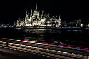 parlament der ungarischen republik bei nacht mit donau und roten autolichtern