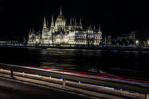 parlement van hongarije in de nacht met donau en met rode autolichten