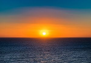 Vue idyllique du coucher de soleil sur la mer avec un beau soleil orange dans le ciel. sur Alex Winter