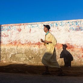 Moroccan man running through streets van Wendy Bos