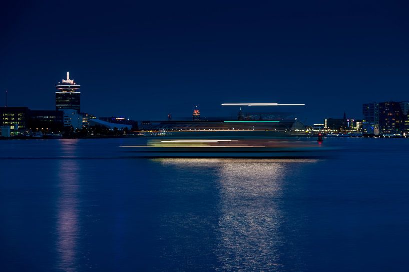 Une partie de l'horizon d'Amsterdam avec des bandes de lumière dans la lumière du soir par Wim Stolwerk