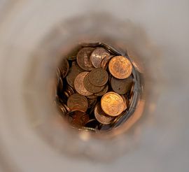 Close-up of European coins in a bottle from above
