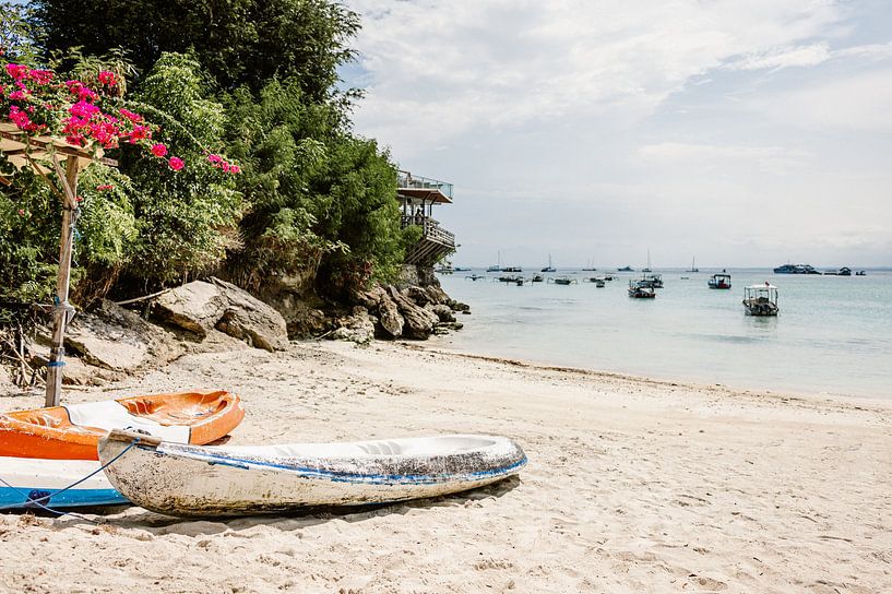 Beach with clear blue sea and boats on the island of Nusa Penida Bali by Lilian Aartman