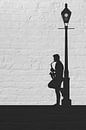 Straatmuzikant met saxofoon in silhouette, een drieluik deel 2 van Arjen Roos thumbnail